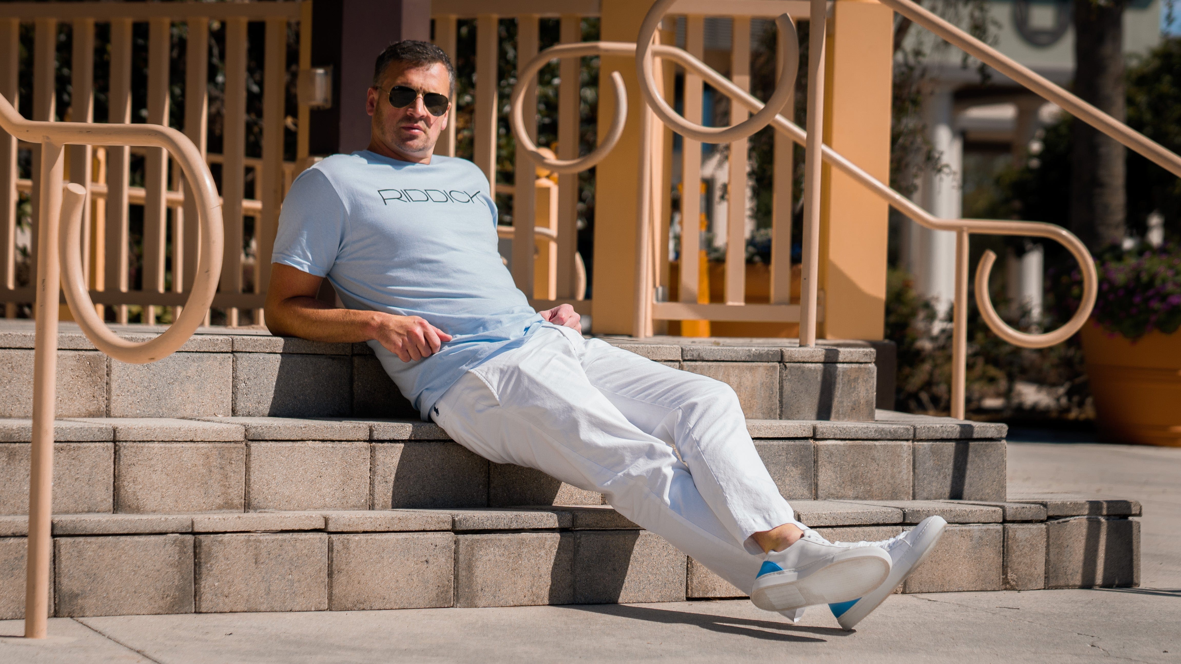 Ryan Lochte wearing a signature baby blue RIDDICK T-shirt and Italian leather shoes. 